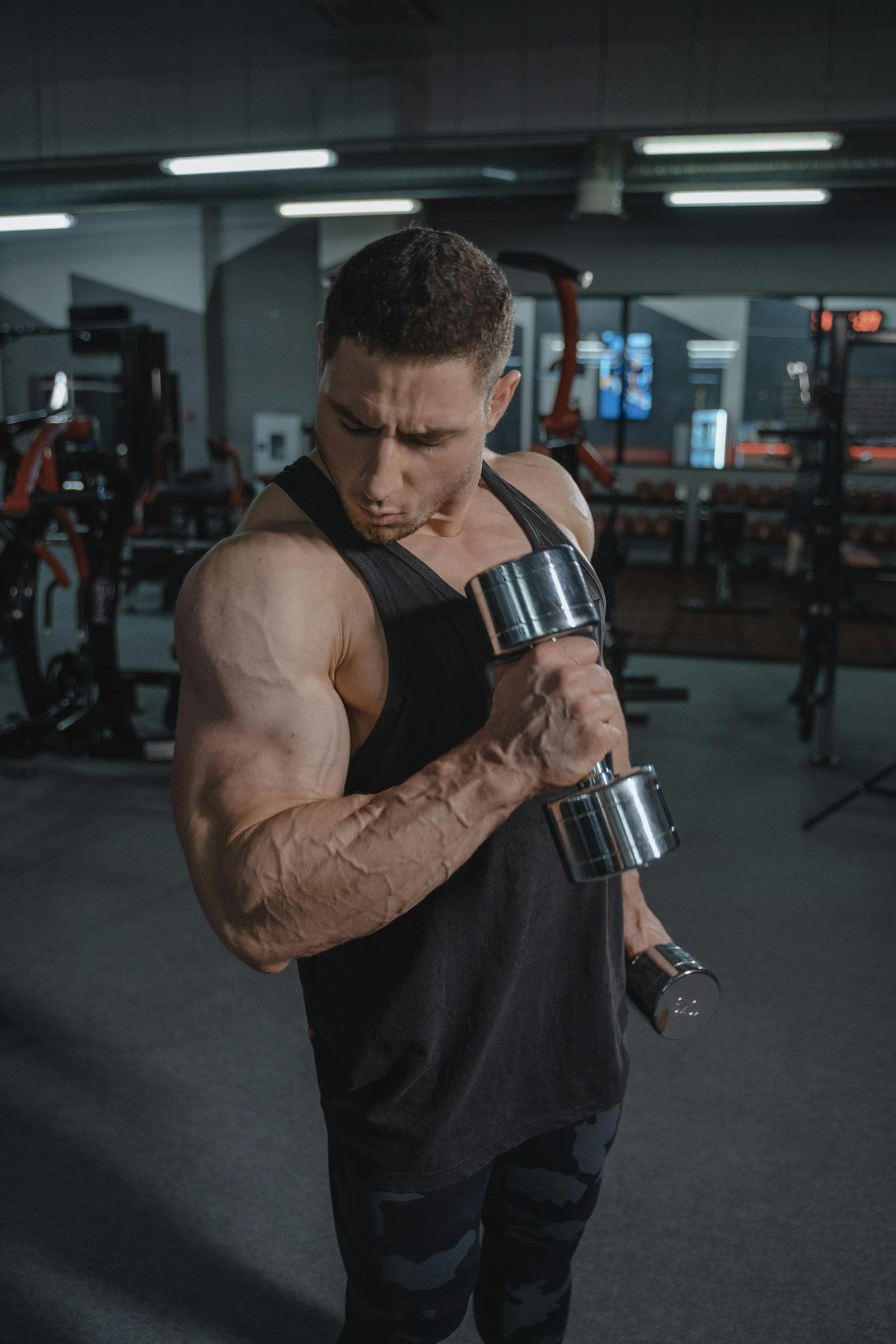 Male athlete lifting dumbbells in a gym
